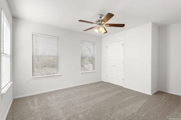an empty room with a ceiling fan and wooden floor