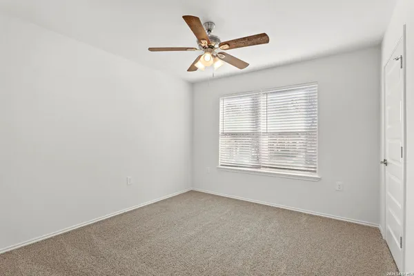 an empty room with closet and fan