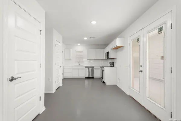 a kitchen with white cabinets and white appliances