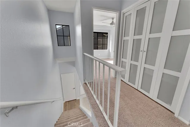 a view of a hallway with wooden floor and stairs