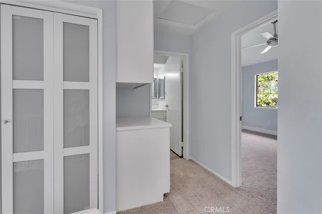 a view of hallway with wooden floor and a mirror