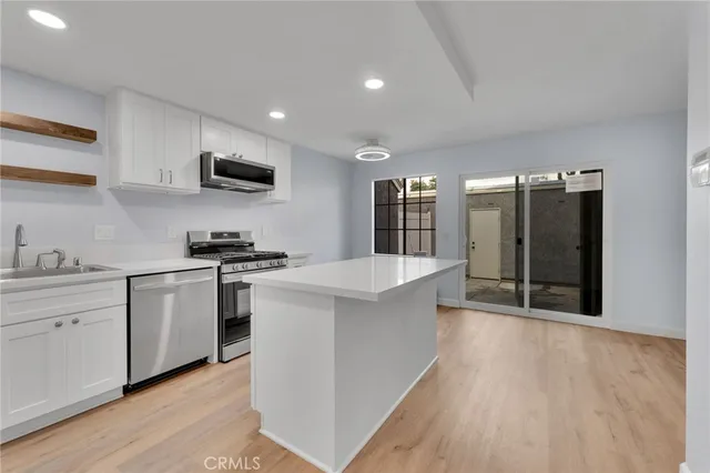 a large kitchen with stainless steel appliances granite countertop a stove a sink and a refrigerator