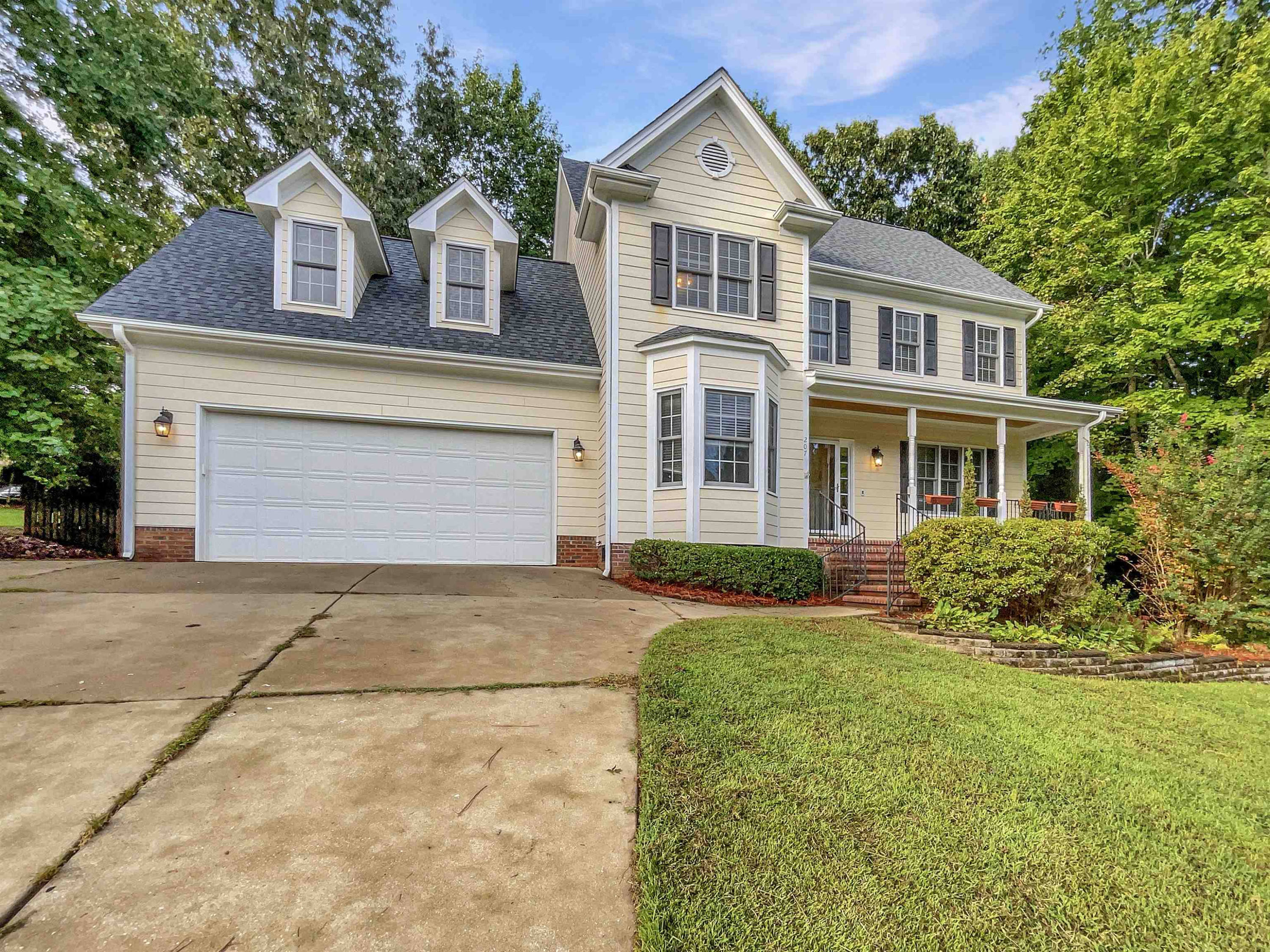 207 Normandy Drive Clayton, NC 27527 - Photo 1 of 25 a front view of a house with a yard and garage