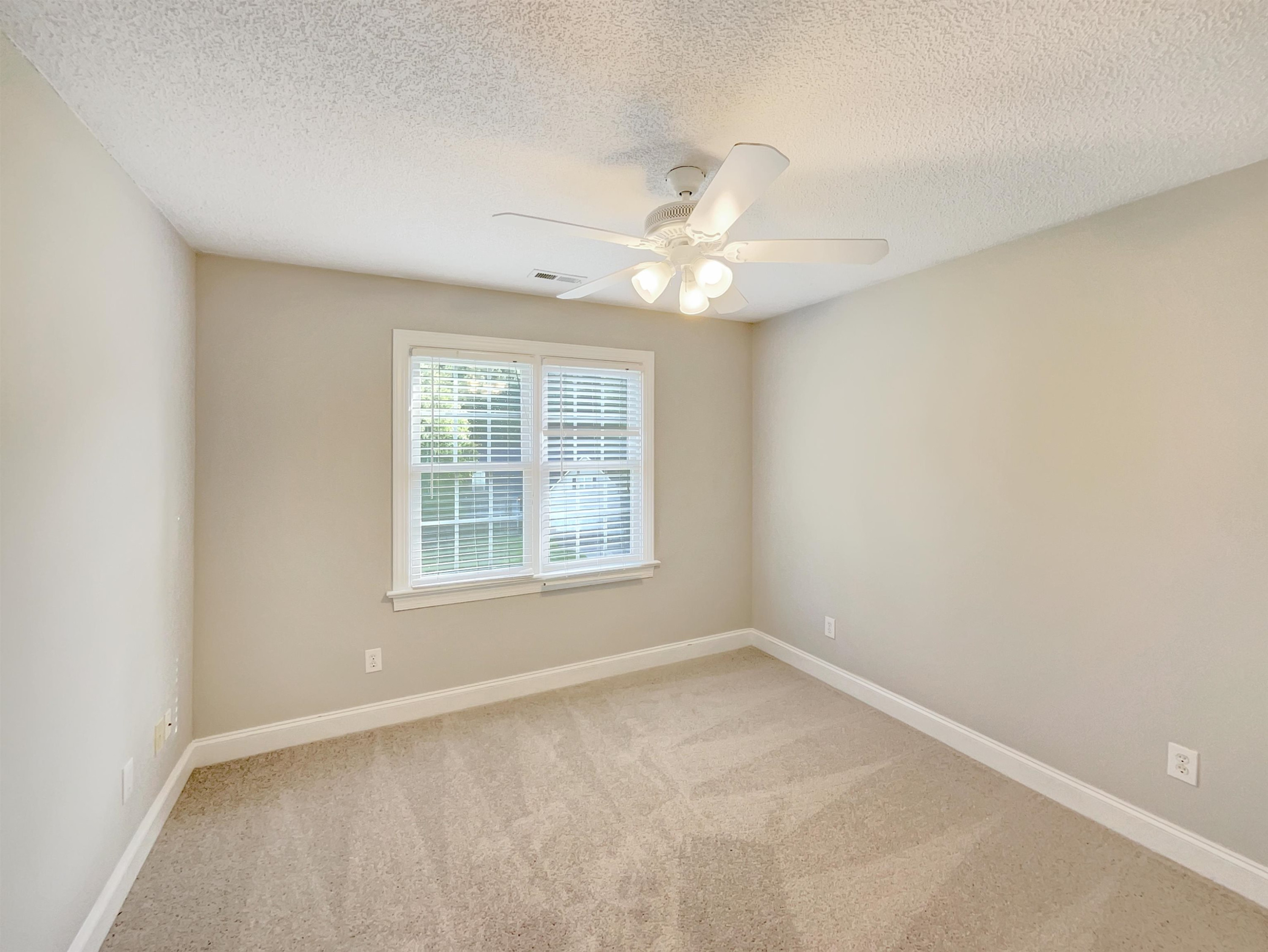 207 Normandy Drive Clayton, NC 27527 - Photo 20 of 25 an empty room with a window and a fan