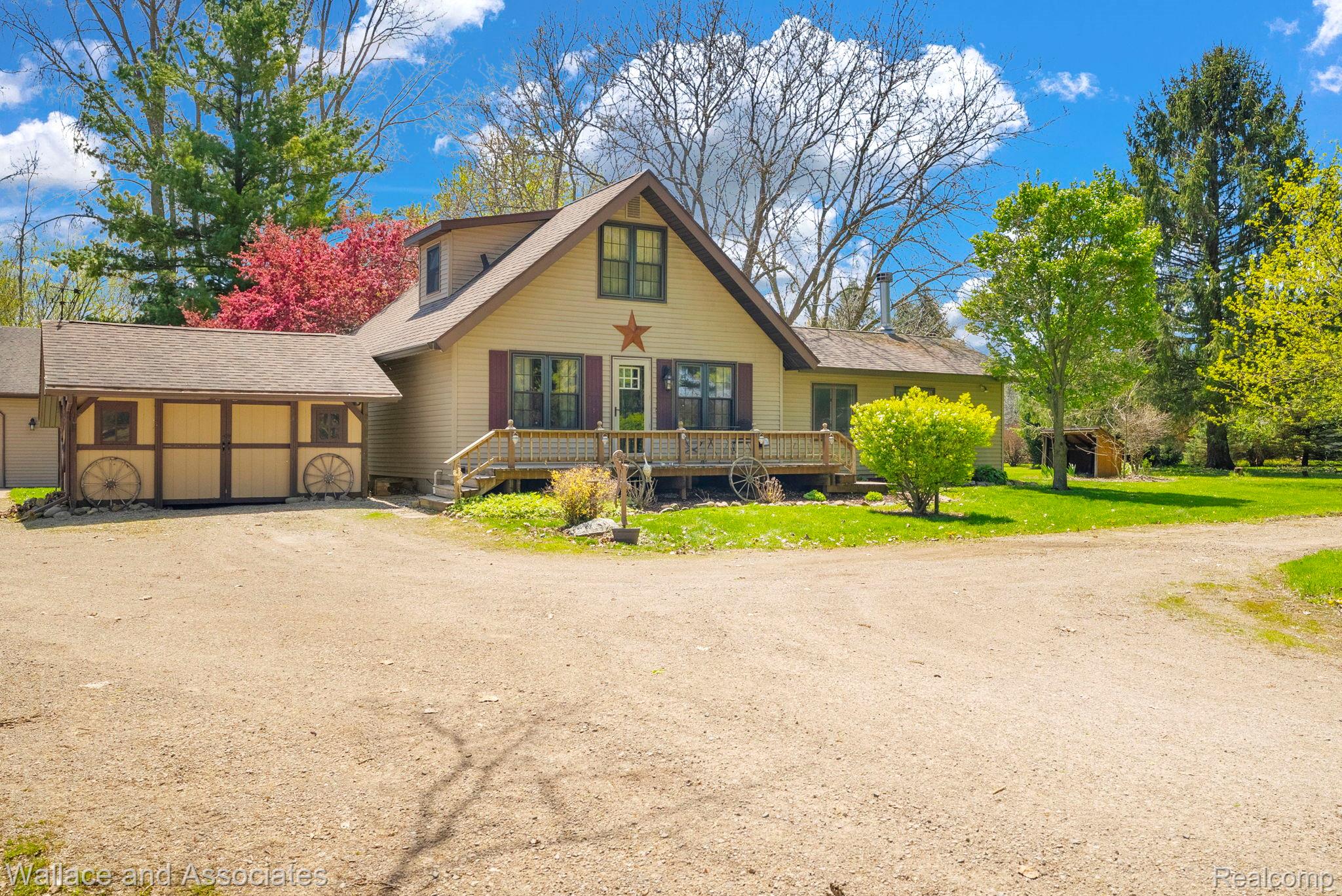 6616 Wellman Line Road Croswell, MI 48422 - Photo 5 of 47 Rustic home featuring dirt driveway, a wooden deck, a shingled roof, and a front lawn