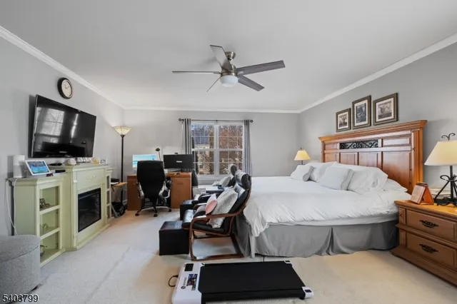a bedroom with a bed a flat screen tv and dresser