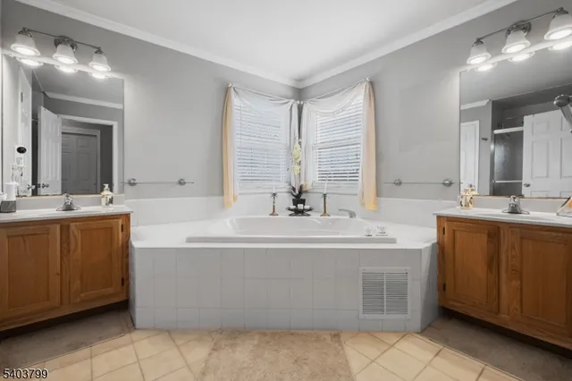 a bathroom with a double vanity sink mirror and bathtub