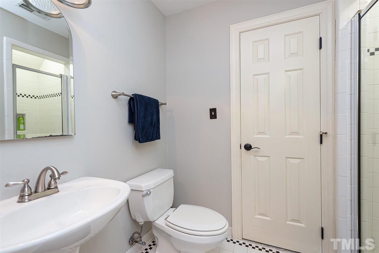 7016 North Ridge Drive Raleigh, NC 27615 - Photo 20 of 30 a bathroom with a toilet a sink a mirror and vanity
