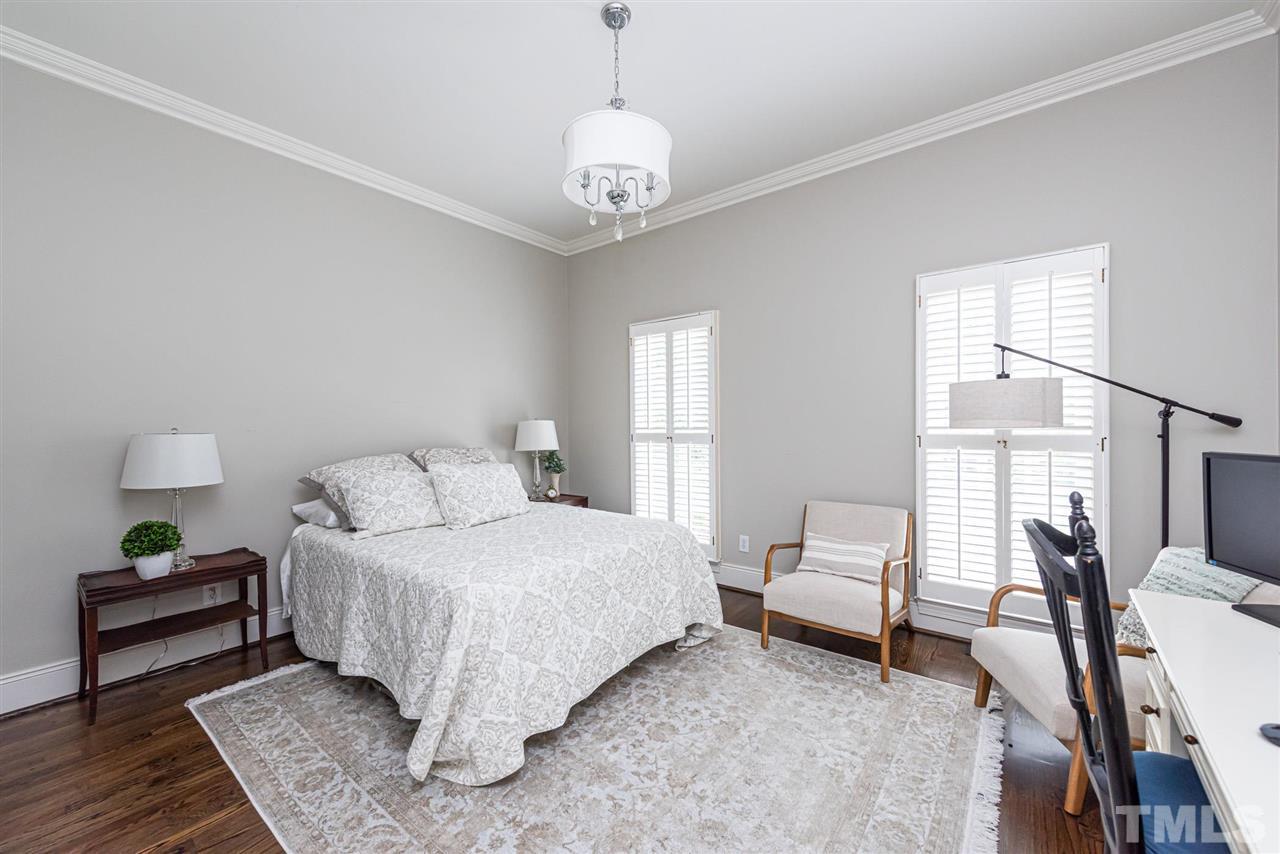 7016 North Ridge Drive Raleigh, NC 27615 - Photo 21 of 30 a bedroom with a bed and a chandelier