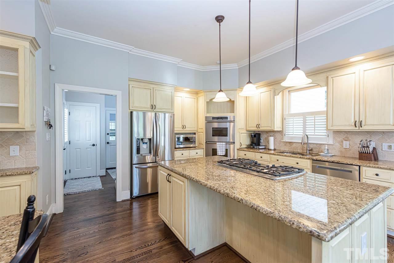7016 North Ridge Drive Raleigh, NC 27615 - Photo 7 of 30 a kitchen with stainless steel appliances granite countertop a sink stove and refrigerator