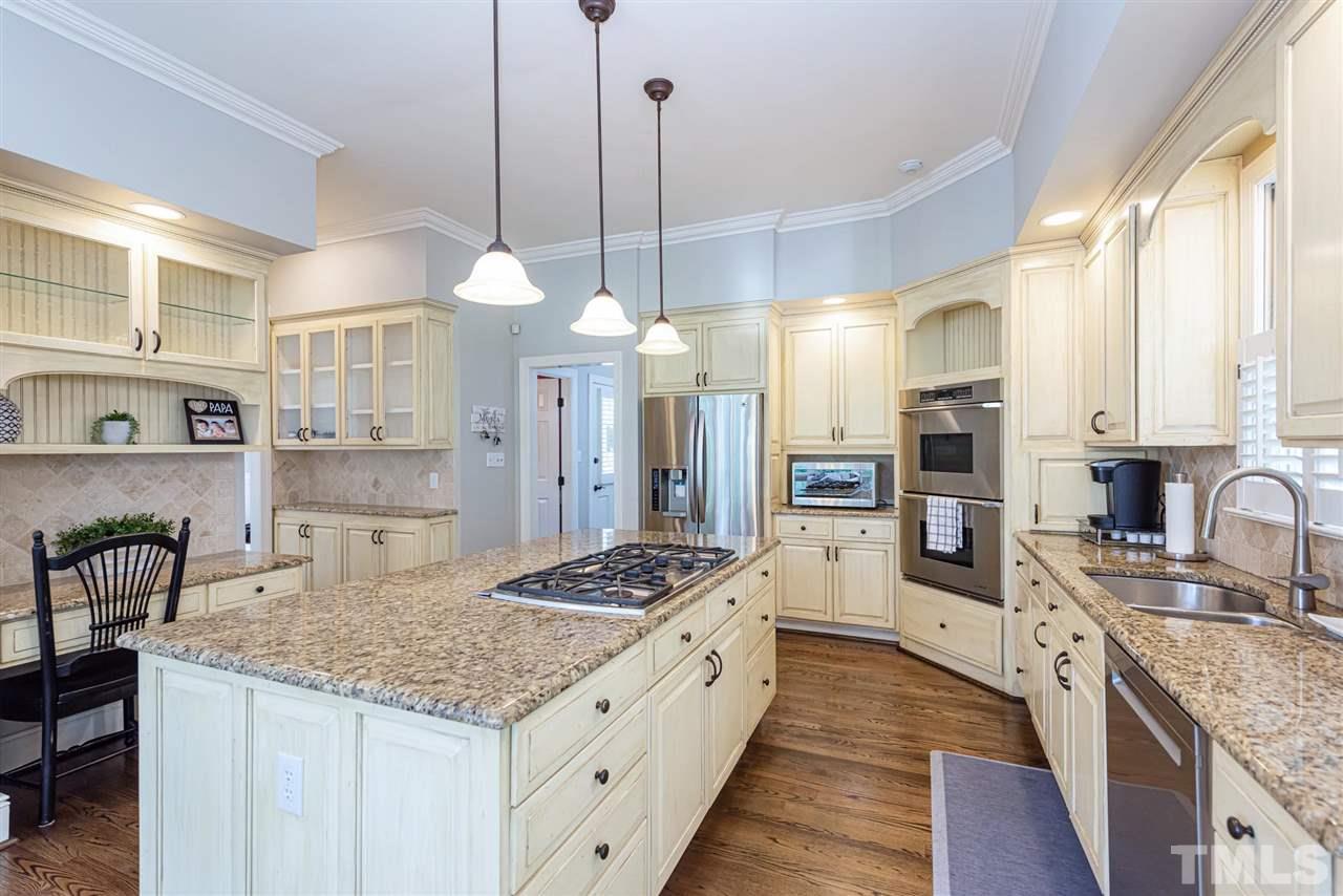 7016 North Ridge Drive Raleigh, NC 27615 - Photo 8 of 30 a kitchen with stainless steel appliances granite countertop a sink stove and refrigerator