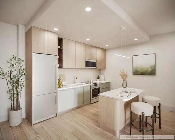 a kitchen with a refrigerator a kitchen island with a stove and white cabinets