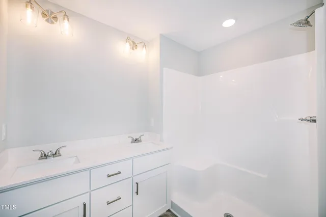 a bathroom with a bathtub sink vanity and mirror