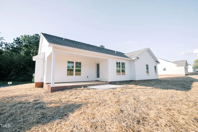 a view of house with backyard and trees