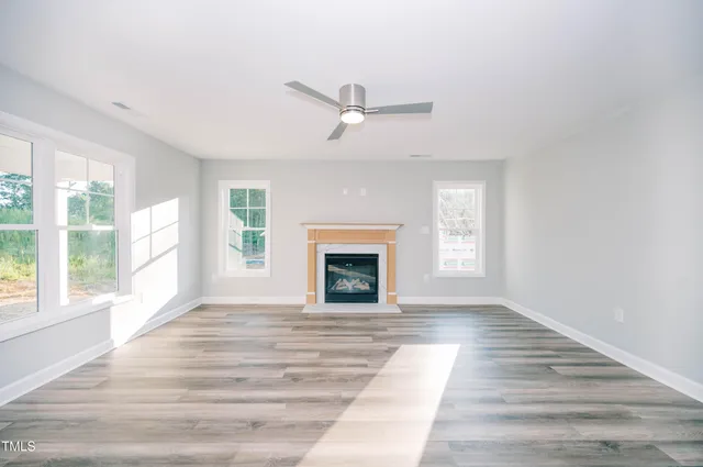 wooden floor fireplace and windows in an empty room