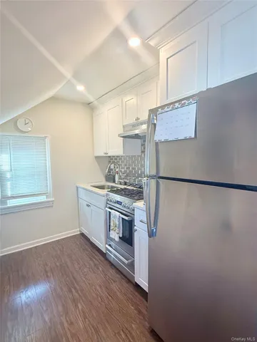 a view of a kitchen with white cabinets