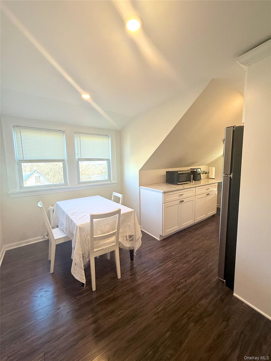 130 Clinton Avenue, Unit 3 New Rochelle, NY 10801 - Photo 5 of 10 Dining Area features vaulted ceiling and dark wood-type flooring