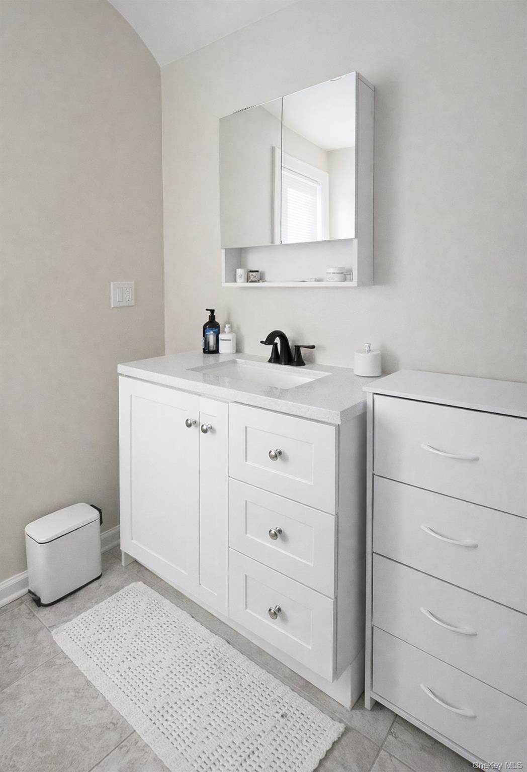 130 Clinton Avenue, Unit 3 New Rochelle, NY 10801 - Photo 9 of 10 a bathroom with a toilet a sink a vanity and mirror