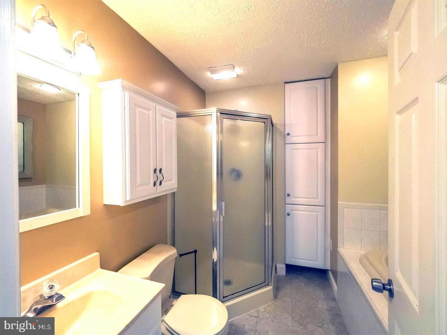 7701 Croom Road Upper Marlboro, MD 20772 - Photo 15 of 46 a bathroom with a shower a sink and a toilet