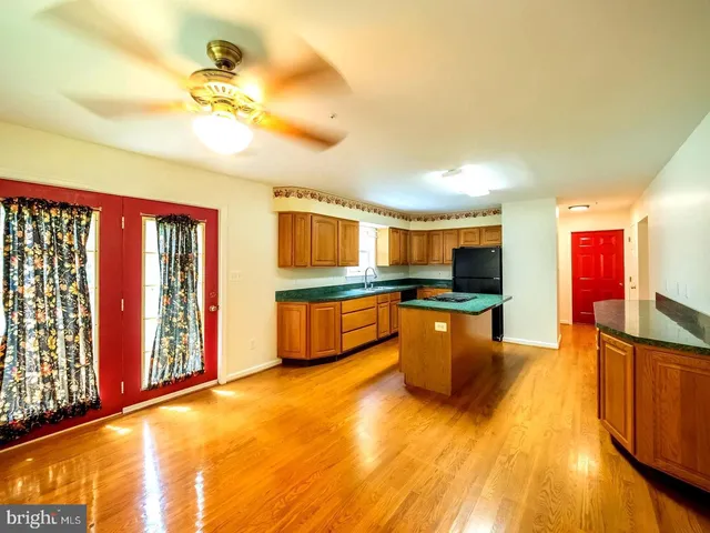 a kitchen with stainless steel appliances granite countertop a sink cabinets and wooden floor