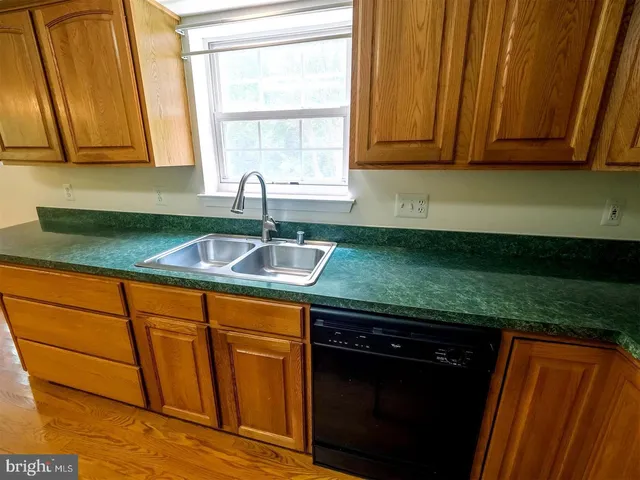 a kitchen with granite countertop wooden cabinets a sink and a stove