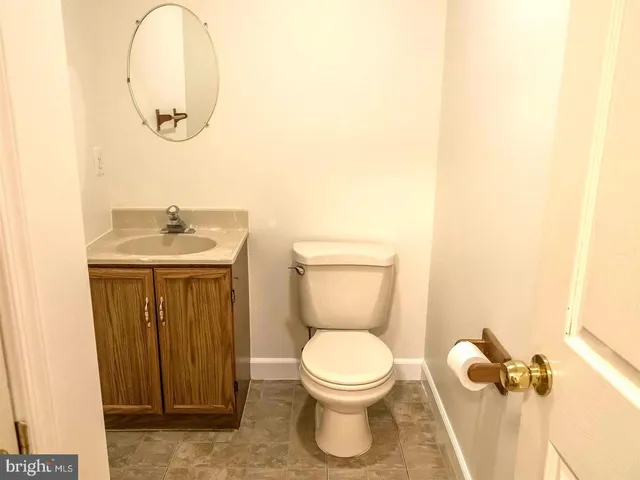 a bathroom with a toilet a sink and mirror