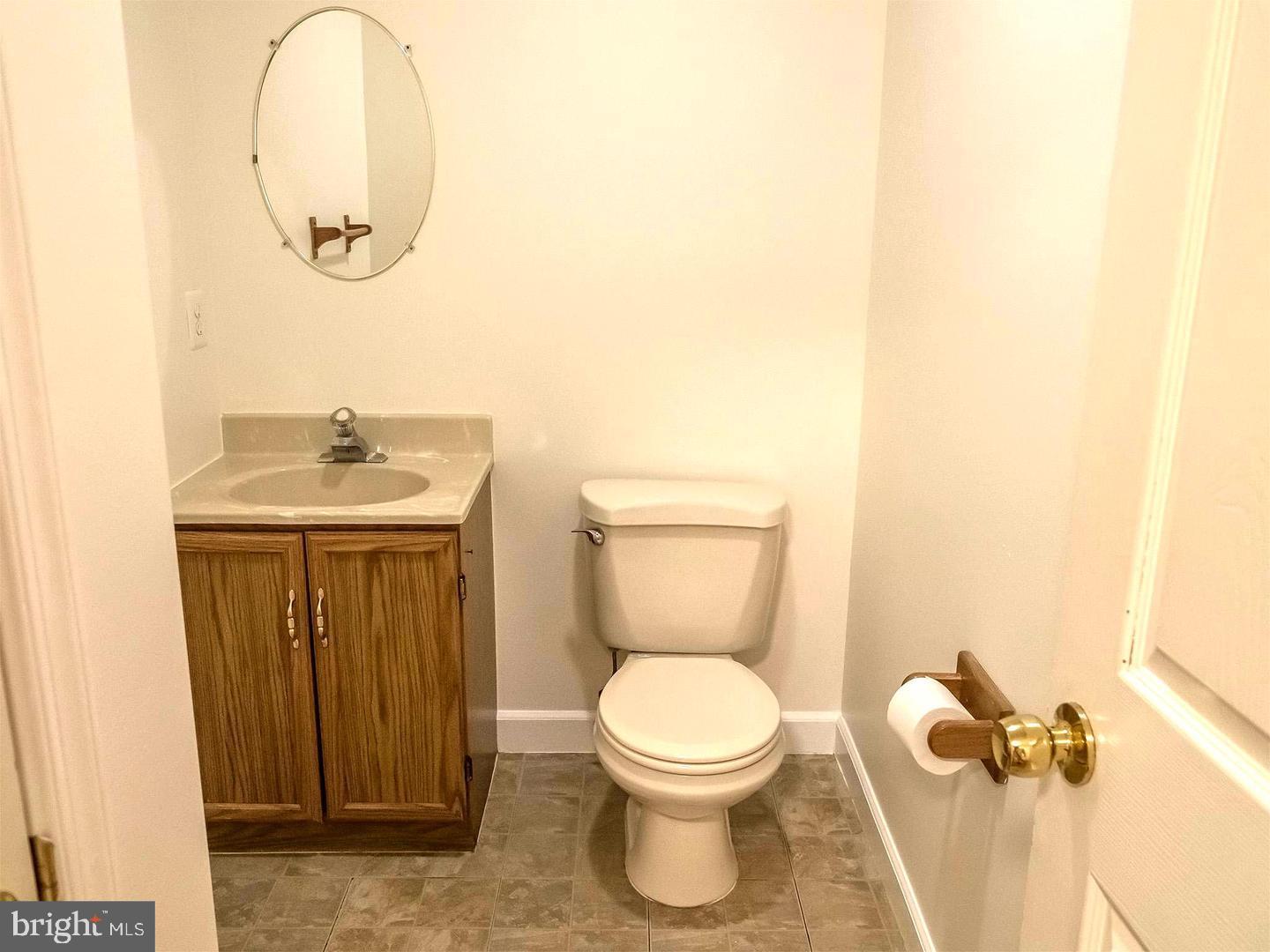 7701 Croom Road Upper Marlboro, MD 20772 - Photo 29 of 46 a bathroom with a toilet a sink and mirror