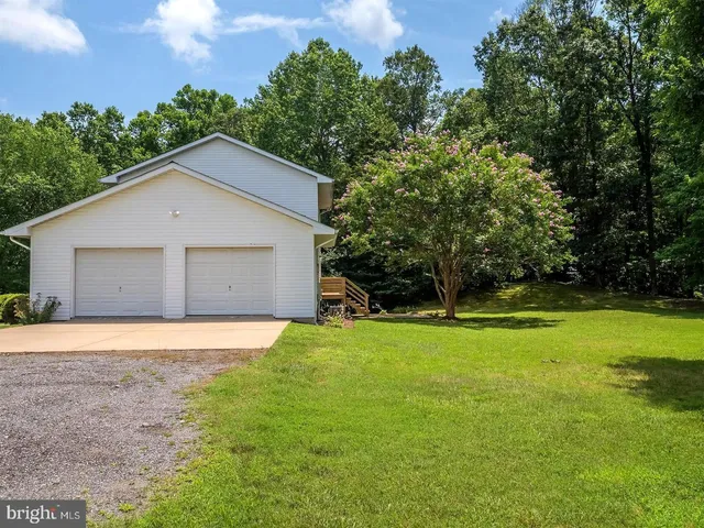 a front view of house with yard and trees in the background
