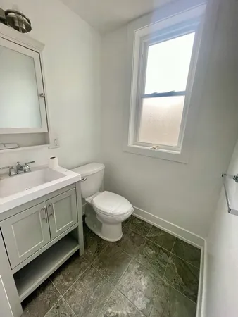 a spacious bathroom with a double vanity sink toilet and a mirror