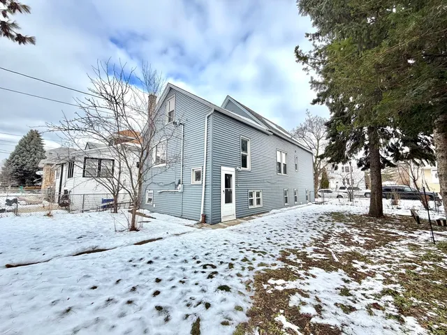 a front view of a house with a yard covered in snow