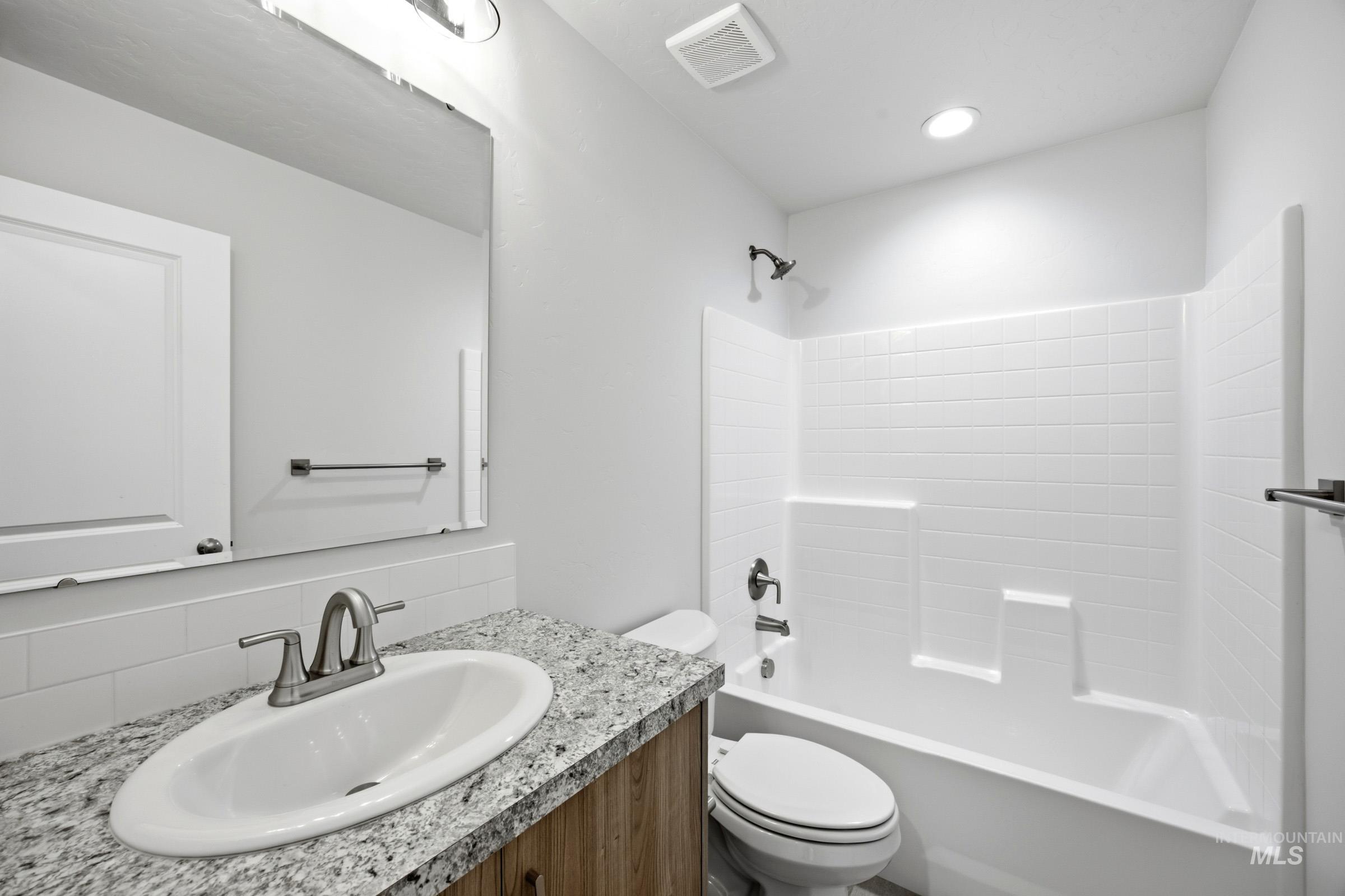 13298 Bank Street Caldwell, ID 83607 - Photo 23 of 23 Bathroom featuring a single vanity with a light-colored countertop, an undermount sink, a chrome two-handle faucet, and a shower-over-tub combination with white subway-style tiling