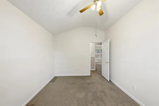 an empty room with a ceiling fan and a window