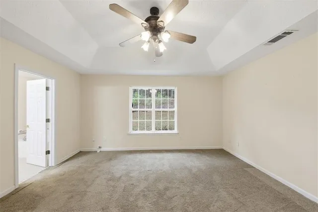 an empty room with chandelier fan
