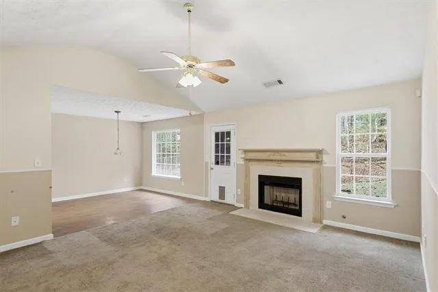 an empty room with windows and fireplace