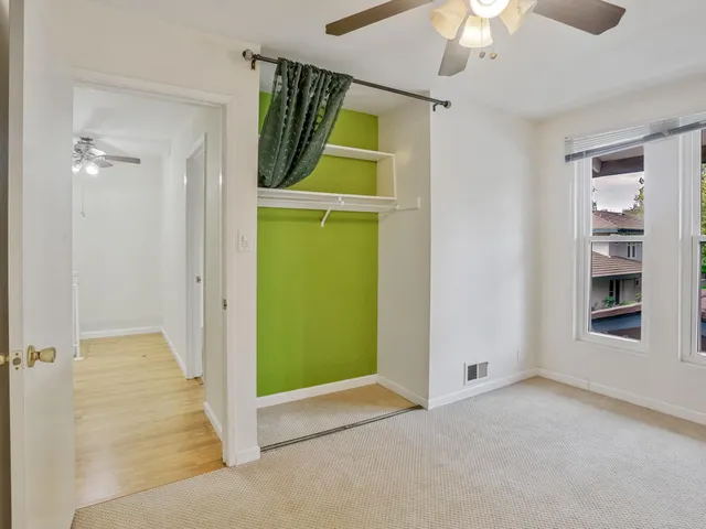 an empty room with windows and fan