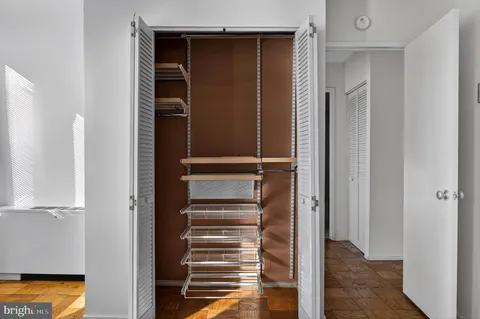 a view of a big room with wooden floor and windows