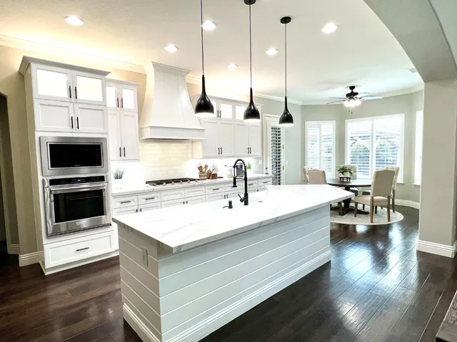 a large white kitchen with stainless steel appliances