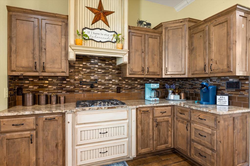 9739 Waldrup Road Lipan, TX 76462 - Photo 13 of 38 Gas cooktop with a pot filler, and gorgeous custom cabinets.