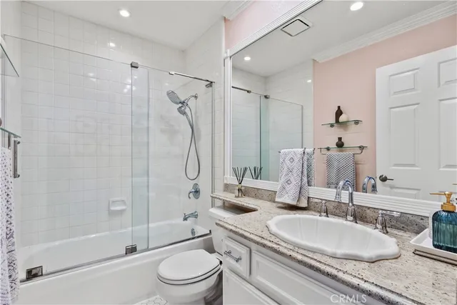 a bathroom with a sink a toilet and a large mirror