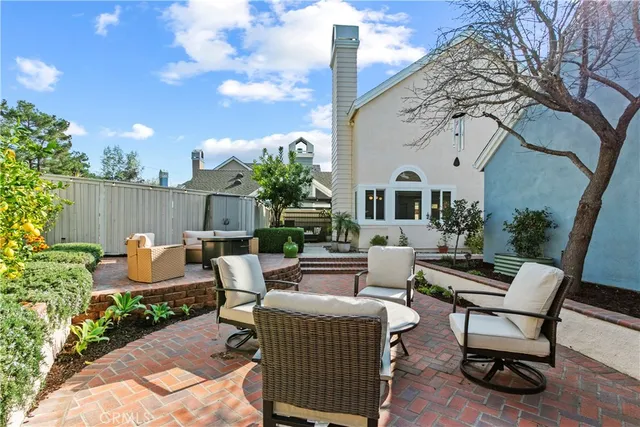 a view of a patio with couches table and chairs and potted plants