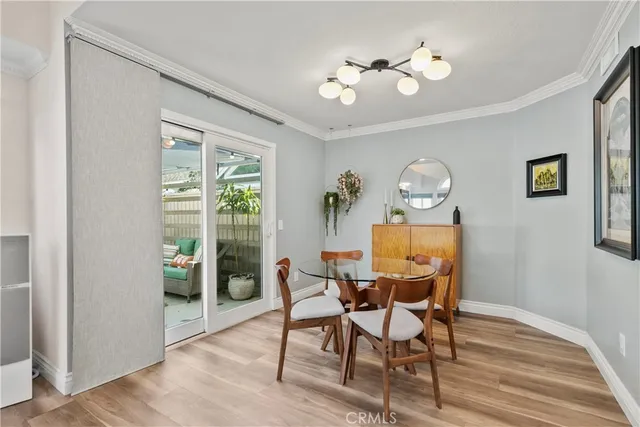 a view of a dining room with furniture a chandelier and wooden floor