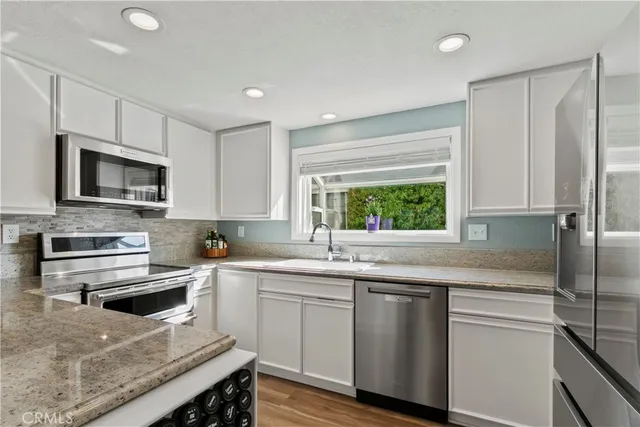 a kitchen with a sink stove top oven and refrigerator