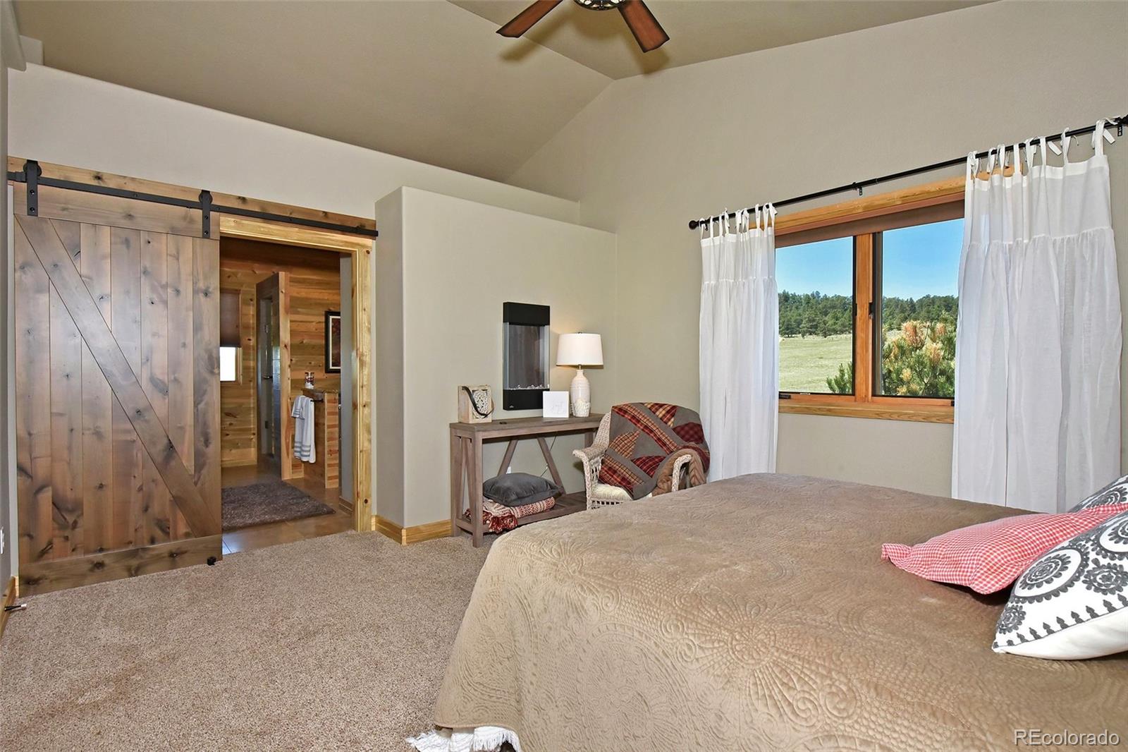 21050 Roxie Ridge View Peyton, CO 80831 - Photo 16 of 40 a bedroom with a bed and a chandelier