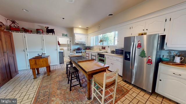 19 Valley Road Lewistown, PA 17044 - Photo 14 of 37 a kitchen with stainless steel appliances a refrigerator a stove a sink dishwasher and a dining table with wooden floor