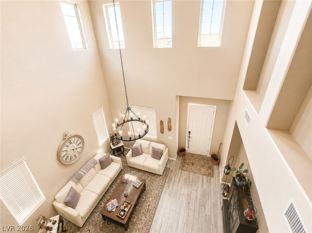 9724 University Ridge Avenue Las Vegas, NV 89149 - Photo 4 of 61 A striking chandelier hangs in this sun-filled living space with soaring ceilings and light flooring.