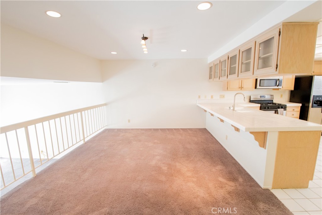 18340 Collins Street, Unit E Tarzana, CA 91356 - Photo 9 of 29 a view of kitchen with stainless steel appliances a sink dishwasher a stove with wooden floor