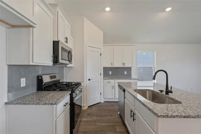 an empty room with wooden floor ceiling fan and windows