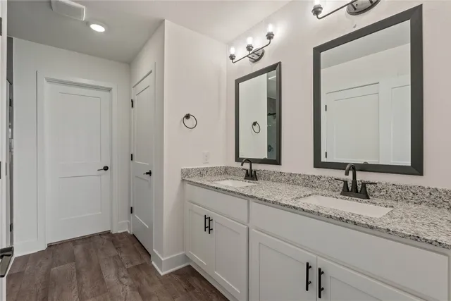 a bathroom with a granite countertop sink a mirror and a bathtub