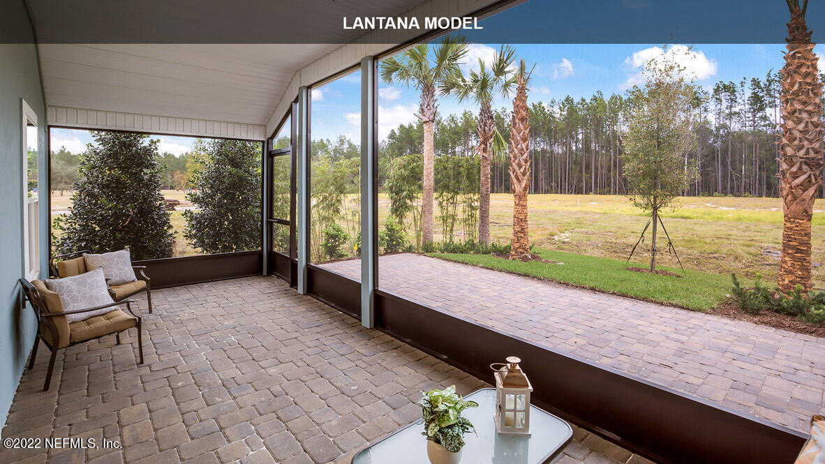 65736 Edgewater Drive Yulee, FL 32097 - Photo 17 of 44 a swimming pool with outdoor seating and a garden