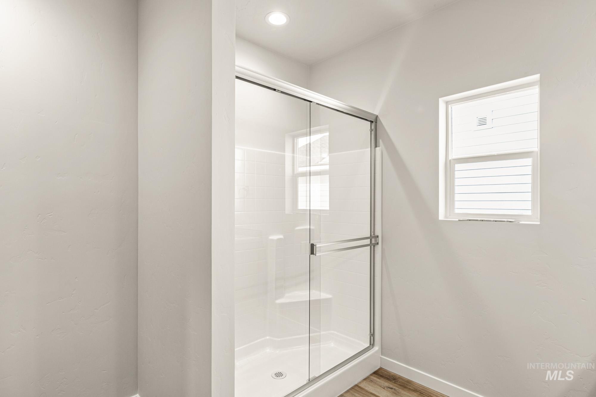 12865 Decatur Street Nampa, ID 83651 - Photo 18 of 20 Glass-enclosed shower with a textured subway tile surround, integrated shelving, and a built-in bench